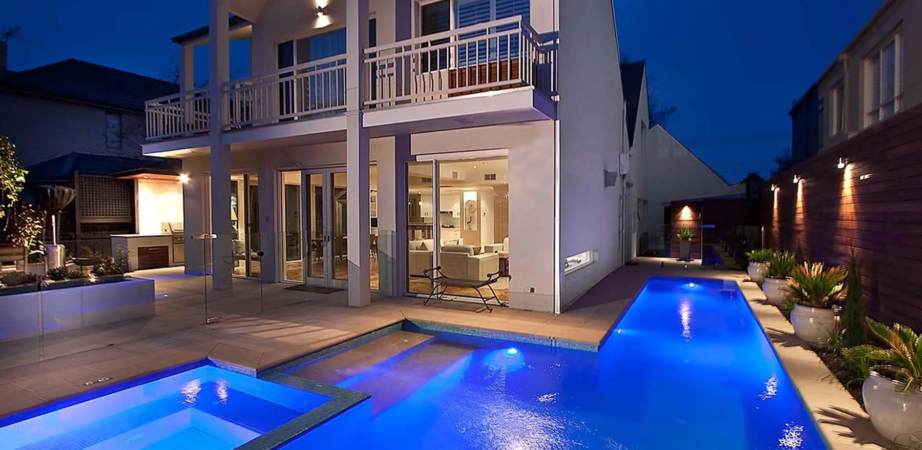 Nighttime view of a stylish home featuring a lap pool