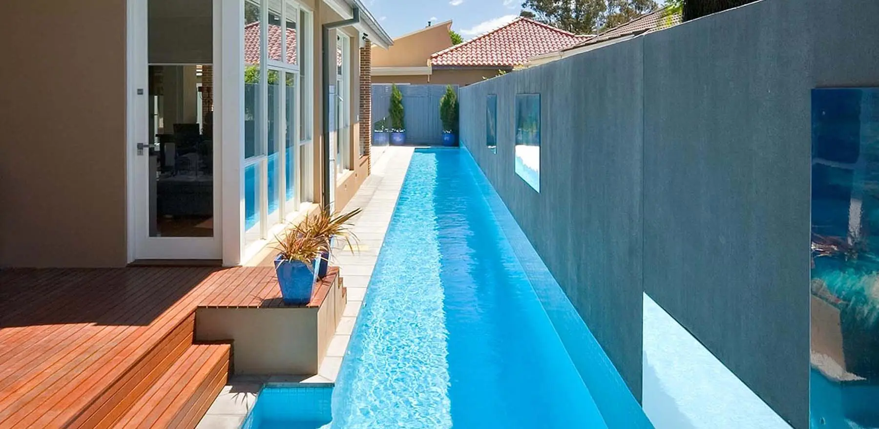 Wooden steps leading into a backyard lap pool